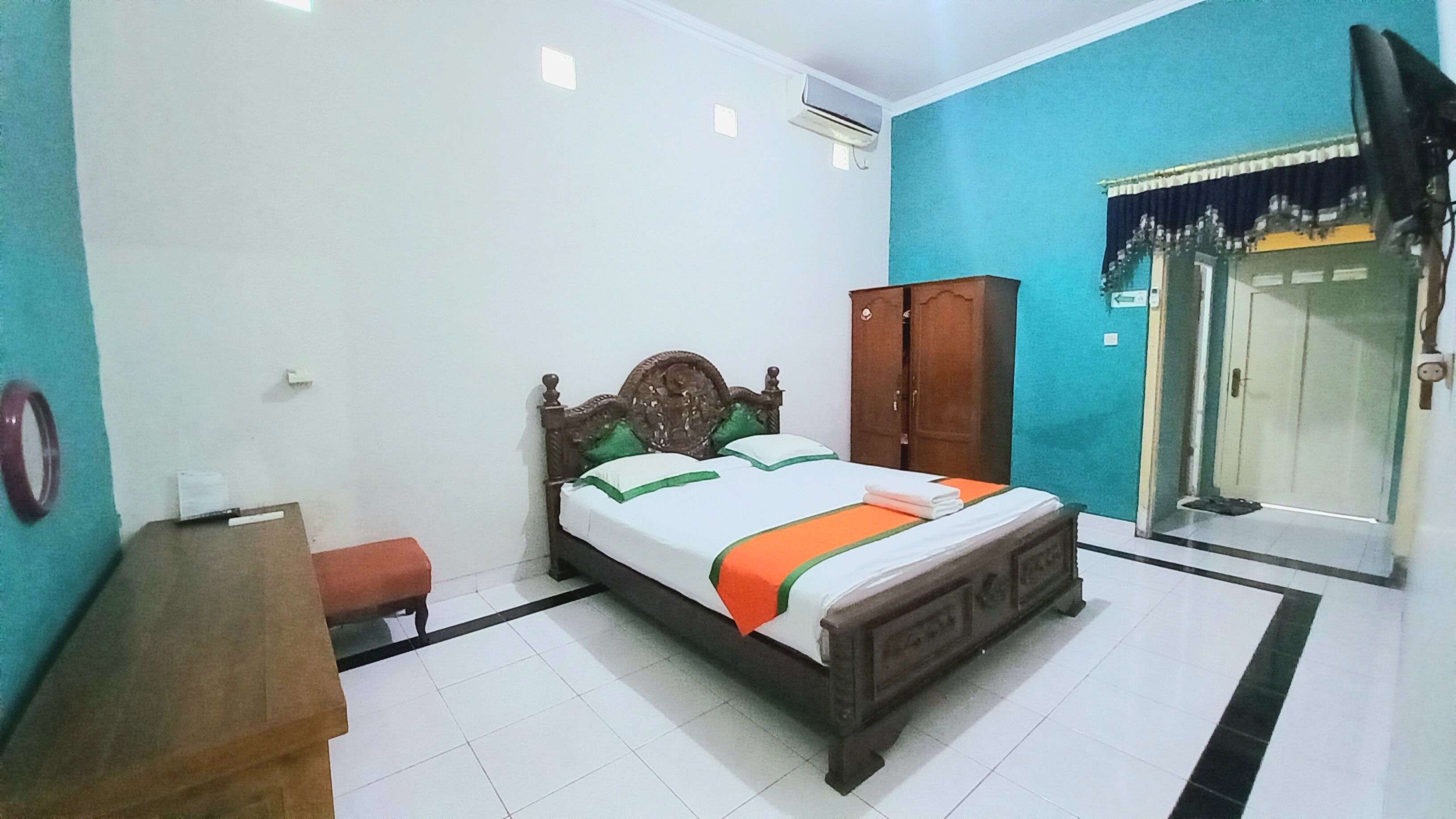 Un dormitorio con cama, armario, escritorio y puerta.