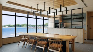Une cuisine moderne dotée de grandes fenêtres offrant une vue panoramique sur la côte.
