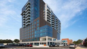 A modern high-rise hotel with a glass facade and multiple balconies. - Four Points by Sheraton Flushing (Flushing)