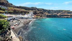 A coastal hotel with a beach view, a rocky shoreline, and a mountainous backdrop. - Apartament Ana with Mountain View, Sea View, Wi-Fi & Terrace (San Marcos)