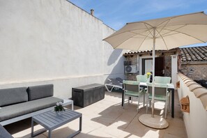 An outdoor patio area with a sofa, a table, a chair, an umbrella, and a fan. - Holiday Home Casa Maria Angela with Sun Terrace, Patio and Wi-Fi (Arta)
