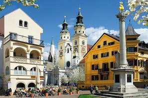 A historic square with a church, a statue, and traditional buildings.