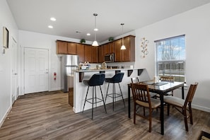 Enjoy cooking in this well-lit kitchen with a central island, bar stools, and a refrigerator.