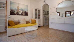 Ein modernes Wohnzimmer mit einer Couch, einem runden Spiegel und einem Stadtbild.