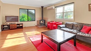 A modern living room with a fireplace, a television, and a leather sofa.