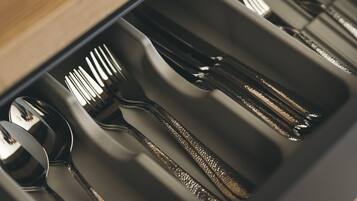 A drawer with utensils including spoons, forks, and knives.