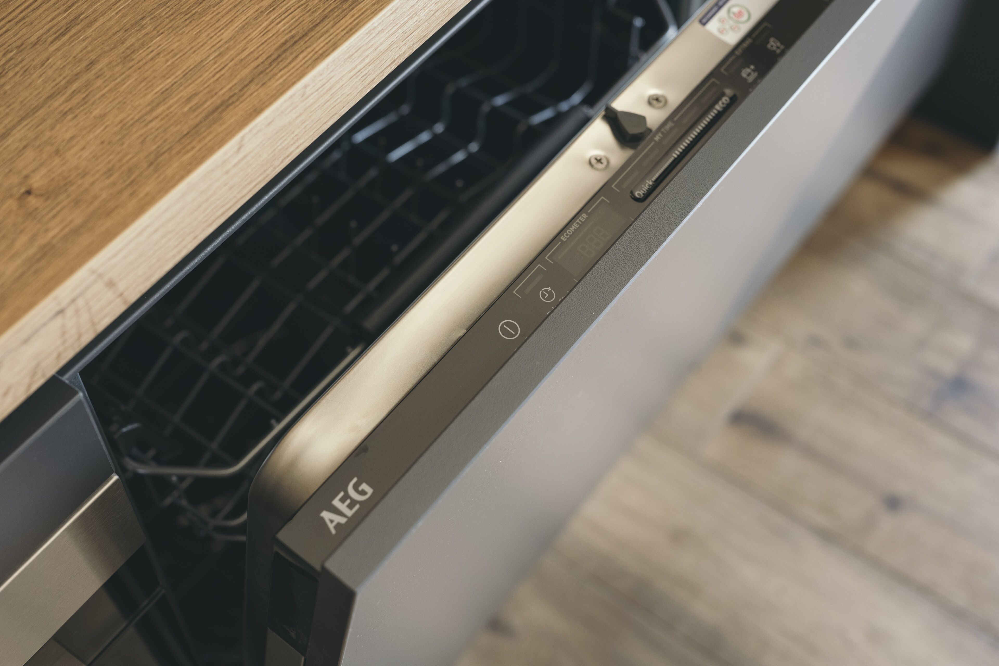 Un lavavajillas con panel de control y encimera de madera.