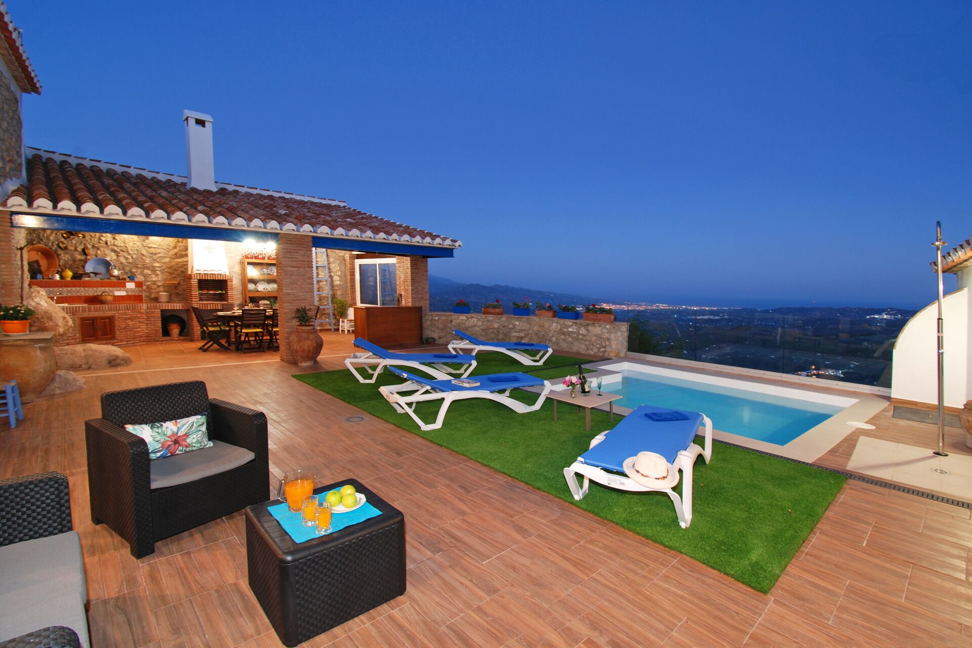Una terrazza sul tetto con piscina, poltrona relax e angolo bar.