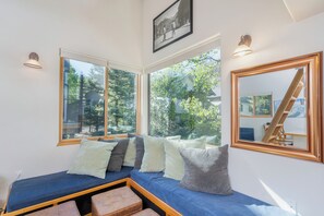 Relax in a comfortable seating area with a bench and enjoy the view of the surrounding greenery from large windows.