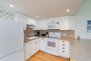 Fully equipped kitchen with refrigerator, microwave, oven, and sink, plus a coffee maker and toaster.