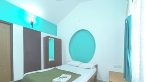 Et soveværelse med seng, garderobeskab, spejl og en rund vægdekoration.