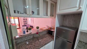 A kitchen with granite countertops, white cabinets, and a stainless steel refrigerator. - Casa Teide, ground floor Parque Santiago 1, heated pool, 100 m to sea+beach (Playa de la Américas)