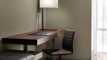 A modern office chair, a desk with a lamp, and a notebook.