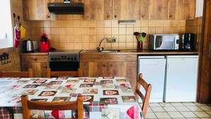 Una cucina con mobili in legno, un fornello, un forno a microonde e un frigorifero.