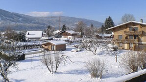 Ein verschneites Dorf mit Holzhäusern und einer Bergkulisse.