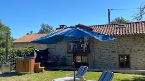 A stone building with a tiled roof, a covered outdoor seating area, and two lounge chairs. - The perfect Couple's Retreat (Abjat-sur-Bandiat)
