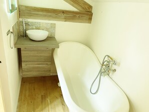 A bathroom with a freestanding bathtub, a wooden vanity with a white sink, and a tiled backsplash. - The perfect Couple's Retreat (Abjat-sur-Bandiat)