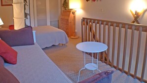 A bedroom with a bed, a small round table, a dresser, and a crib. - Apartment for 5 with private balcony and parking in Samoëns (Samoëns)