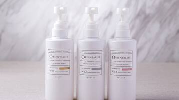 Three bottles of Wakan Natural Plants Orientalist shampoo, treatment, and body soap.
