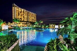 A hotel with a large pool area, surrounded by palm trees and well-lit pathways. - Oriental Hotel Okinawa Resort & Spa (Nago)