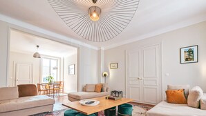 Ein modernes Wohnzimmer mit einem Holztisch, zwei Sofas und einem Essbereich mit Stühlen.
