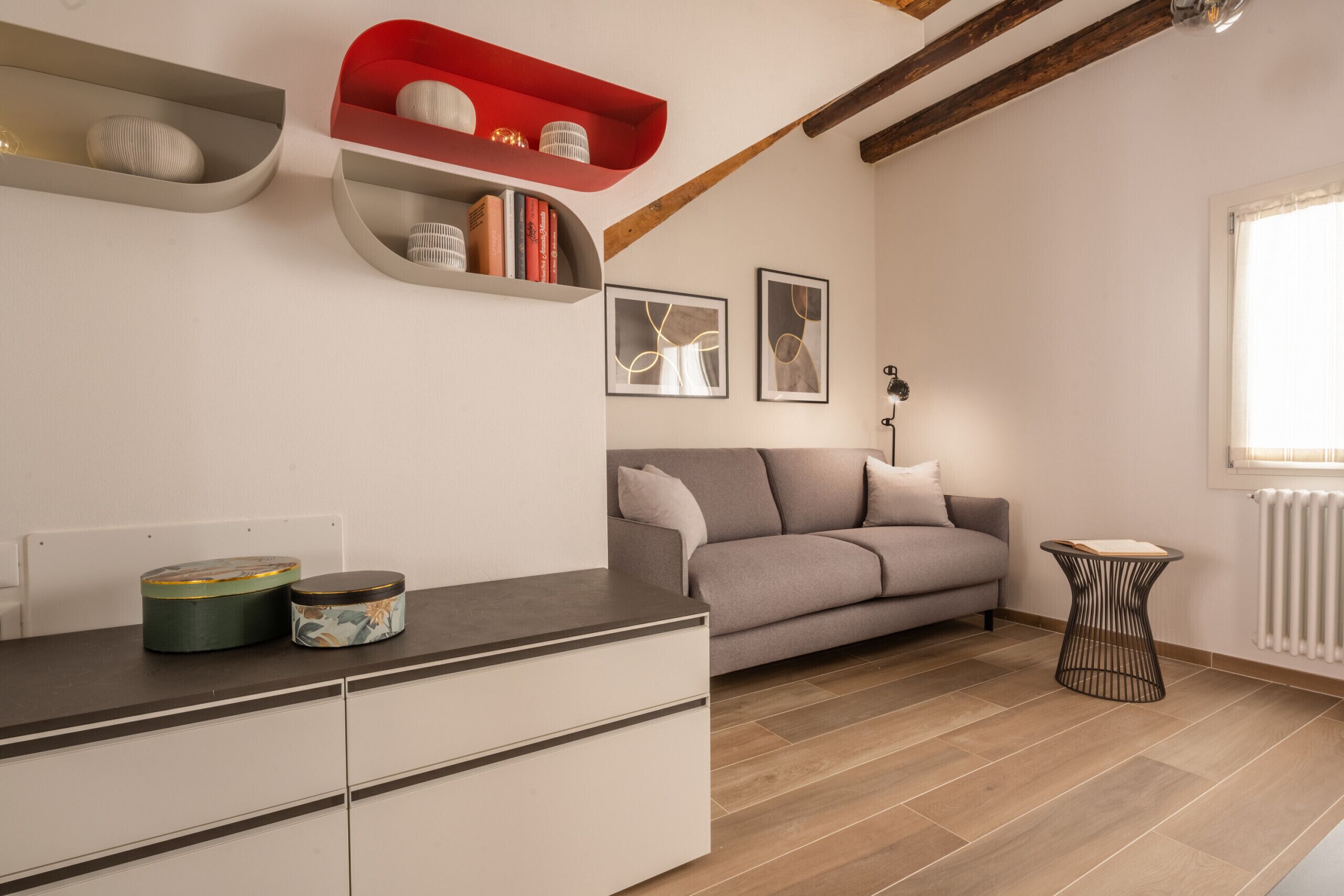 Ein modernes Wohnzimmer mit einer Couch, einem Couchtisch und einer Anrichte mit Dekorationselementen.