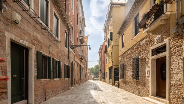 A narrow cobblestone street flanked by historic buildings with visible door numbers and traditional shutters. - San Giacomo dall'Orio Garden Apartment R&R (Venecia)