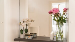 A shelf with potted plants and containers, a mirror, and a radiator. - San Giacomo dall'Orio Garden Apartment R&R (Venecia)