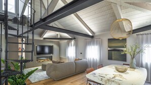 A modern living room with a sofa, dining table, and TV. - San Marco View Terrace Apartment R&R (Venecia)