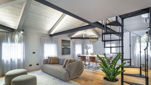 A spacious living area with a high ceiling, a built-in staircase, and a dining area. - San Marco View Terrace Apartment R&R (Venecia)