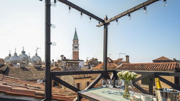 A rooftop terrace with a table set for dining, a view of historic buildings, and a clear sky. - San Marco View Terrace Apartment R&R (Venecia)