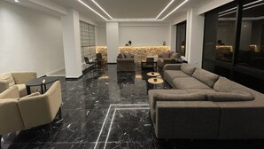Un salon moderne comprenant un canapé d’angle, une table basse et un coin repas avec des chaises et une table.