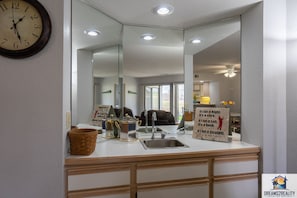 Spacious bathroom with a large mirror, sink, and modern design.