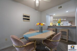 A dining area with a table, chairs, and a vase with flowers.