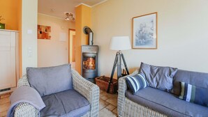 A living room with two grey sofas, a fireplace, a lamp, and a framed picture on the wall.