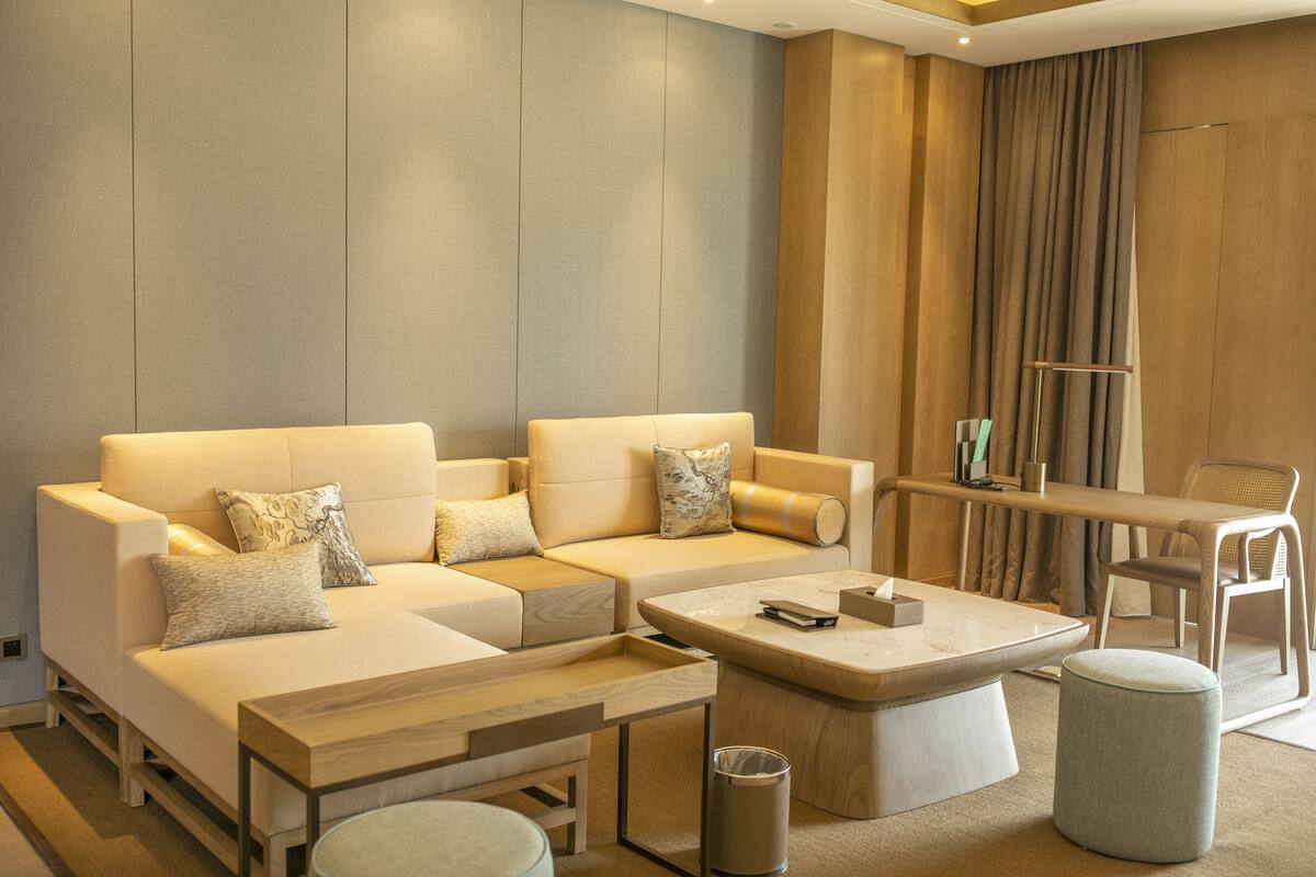 Een moderne woonkamer met een zithoek, een salontafel, een bijzettafeltje en een stoel.