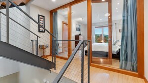 A modern interior with a staircase, a glass door leading to a bedroom, and a view of the outdoors. - LOVELY VIEWS from this beautiful modern townhome in DT Hood River!! (Hood River)