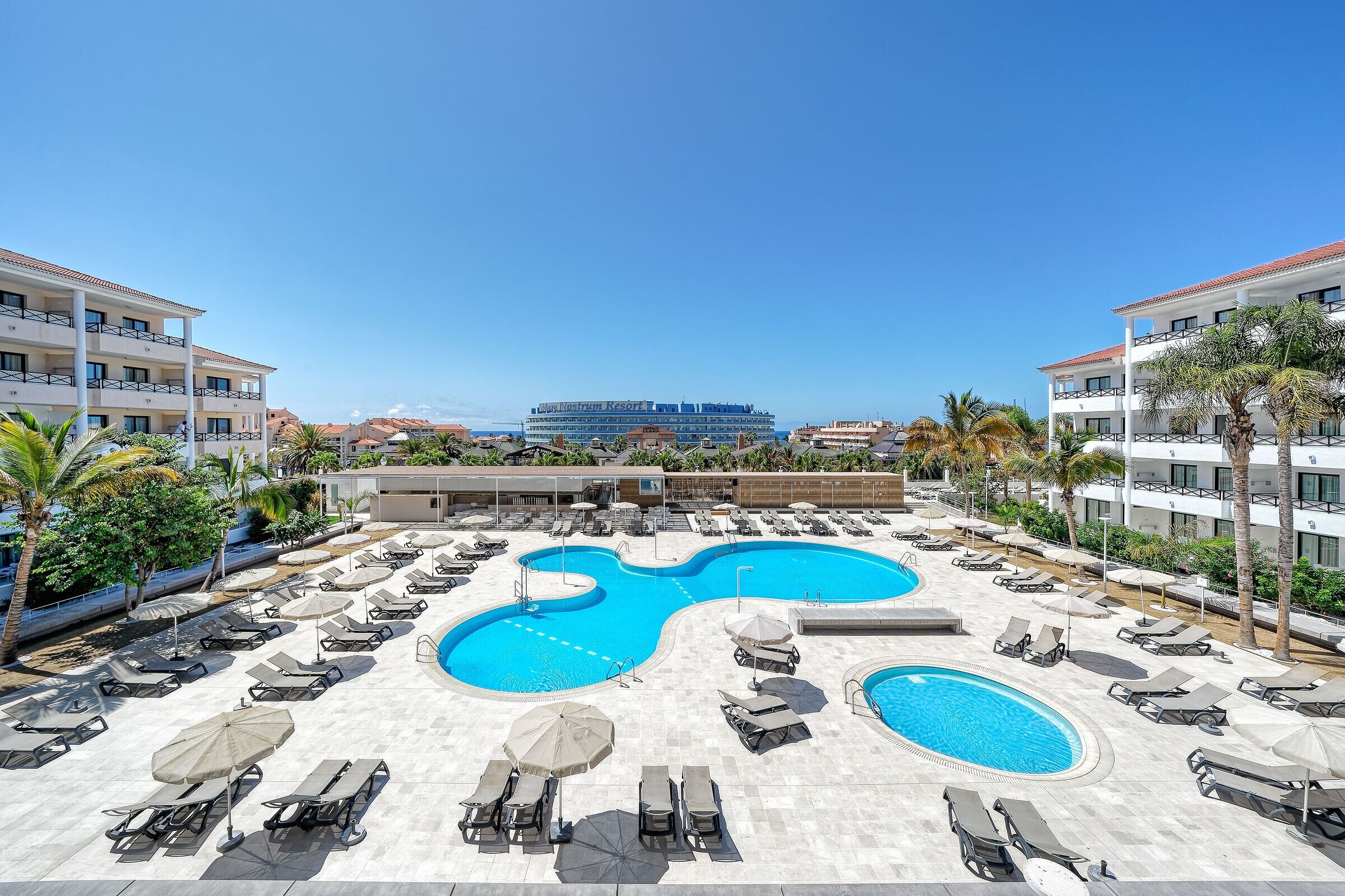 2 utendørsbassenger og solsenger