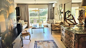 Ein geräumiges Wohnzimmer mit großem Fenster, einem Sofa, einem Couchtisch und einer dekorativen Skulptur.