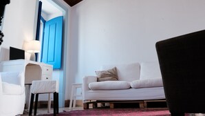 A modern living room with a wooden ceiling, white furniture, and a blue door in the background. - Azoia 10 (Santarém)
