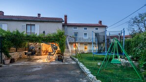 Un quartier résidentiel doté d’une terrasse, d’un espace salon extérieur, d’une balançoire et d’un escalier menant à un balcon situé au deuxième étage.