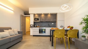 Una cocina moderna con comedor, un sofá y una planta en maceta.