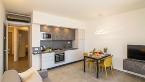 Una cocina moderna con comedor, sofá y televisor.