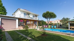 A two-story house with a covered patio, a swimming pool, and a well-maintained lawn. - Apartment Twisting By The Pool - Two bedroom apartment with private pool (Zadar)