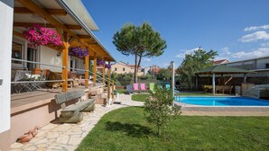 A poolside area with a wooden pergola, stone steps, and outdoor furniture. - Apartment Twisting By The Pool - Two bedroom apartment with private pool (Zadar)