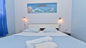 A neatly made bed with blue bedding, two pillows, and two rolled towels. - Holiday Agava - Three Bedroom Apartment With terrace (Razanac)