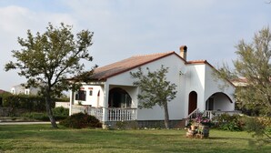 A white building with a red-tiled roof, arched windows, and a small porch with a railing. - Holiday Agava - Three Bedroom Apartment With terrace (Razanac)
