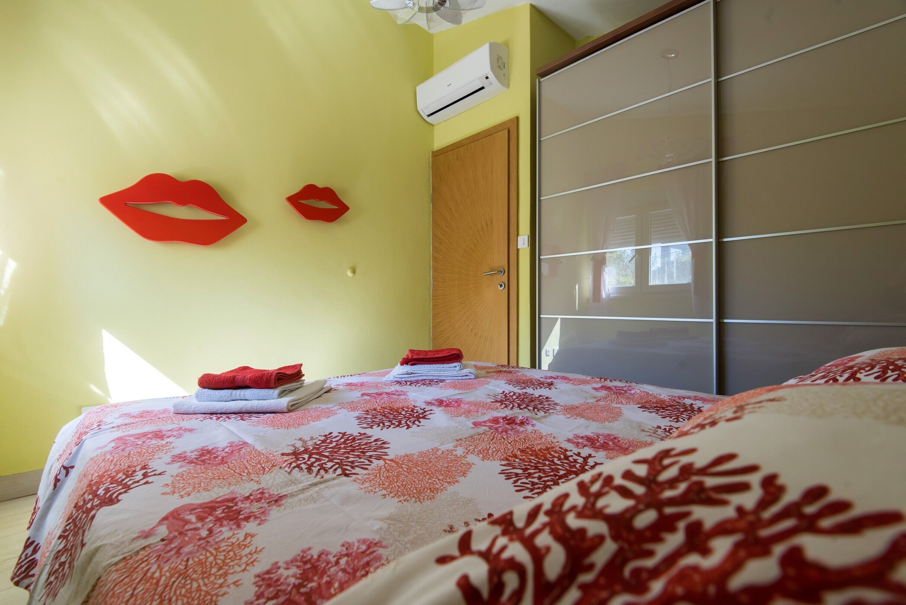 A room with a bed, a wardrobe, and a wall-mounted air conditioner.