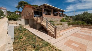 A two-story building with a covered outdoor area and a staircase leading to the upper floor. - NOSTALGIJA three bedroom holiday home with sea view terrace (Brgulje)