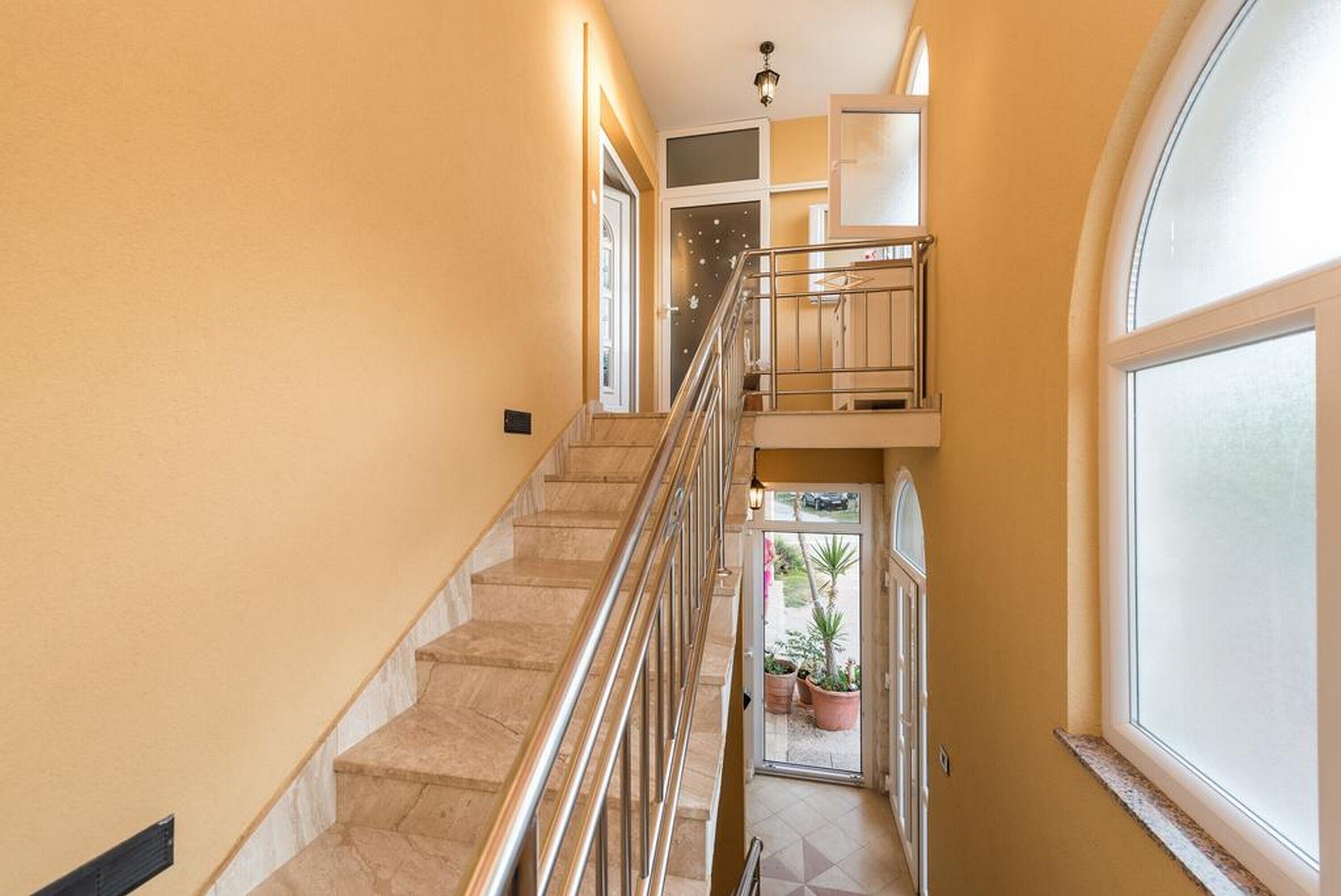 A staircase with a metal railing leading to an upper floor.